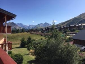 uitzicht op een tuin met bergen op de achtergrond bij Charming duplex in La Toussuire