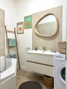 a bathroom with a sink and a mirror at Le cocon du Roi Jérôme - Hypercentre in Ajaccio