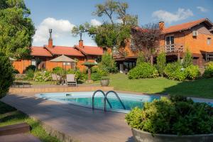 a swimming pool in front of a house at Hotel Canto Verde in Gramado