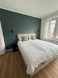 ein Schlafzimmer mit einem großen weißen Bett und einer blauen Wand in der Unterkunft Apartment 3 Eilenriede in Hannover