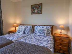 Un dormitorio con dos camas con almohadas azules y blancas. en Broadstones, en Bridport