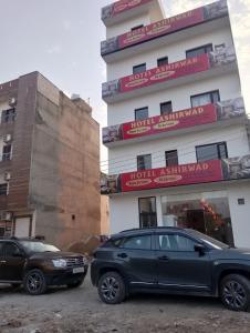 パティヤーラーにあるhotel ashirwadの建物の前に駐車した車両2台