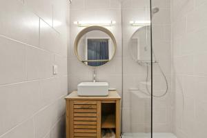 ein Badezimmer mit Waschbecken, Spiegel und Dusche in der Unterkunft Appartement Le Lavandou - Cavalière in Le Lavandou + 17 Fotos