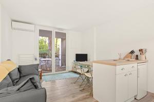 ein Wohnzimmer mit Sofa und eine Küche in der Unterkunft Appartement Le Lavandou - Cavalière in Le Lavandou