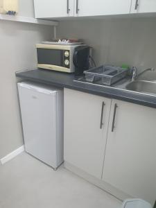 a microwave sitting on top of a counter in a kitchen at Cottage Rose in Bloemfontein