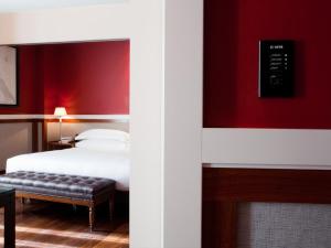 a bedroom with a bed and a red wall at Hotel 1898 in Barcelona