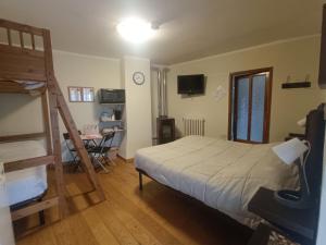 a bedroom with a bed and a ladder and a desk at B&B LA MARMOTTA in Coazze
