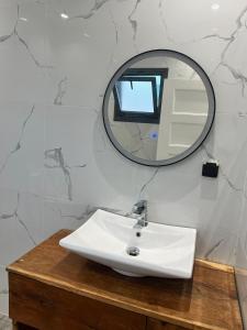 Un baño con un lavabo blanco y un espejo. en Villa Prestige Somone, en Somone 50 fotos más