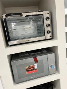 un horno tostador y un microondas en un armario en Villa Prestige Somone, en Somone