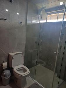 a bathroom with a toilet and a glass shower at Pousada brilho Ametista 2 "apartamentos individuais " in Ametista do Sul