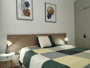a bedroom with a bed and two pictures on the wall at Casa 35 Barrio El Charco Puerto del Rosario in Puerto del Rosario