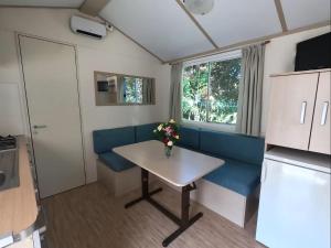 ein Wohnzimmer mit einem Tisch und einem blauen Sofa in der Unterkunft Camping Solcio in Lesa