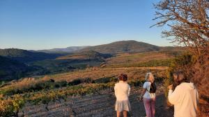three women standing on a dirt road looking at the mountains at La Barbacane de Cascastel-des-Corbières in Cascastel-des-Corbières +6 photos