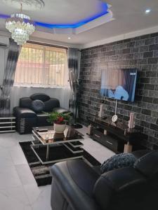a living room with a couch and a tv at Home Away from Home - Gowon Estate near Gemade, Ipaja, Lagos in Lagos