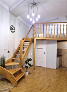 クラクフにあるAriadna - Pantheon Apartmentsのロフト(木製の階段付)