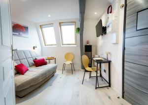 a living room with a couch and a table and chairs at Le petit joyau de Voltaire in Saint-Quentin