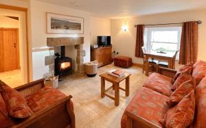 a living room with a couch and a fireplace at 1 Swollowholm Cottage in Richmond
