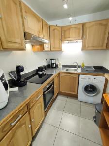 Una cocina con muebles de madera y lavadora. en Apartment with Pool Air Conditioning WiFi and Garage, en Collioure