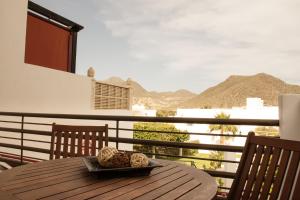 een houten tafel met een bord eten op een balkon bij Apartamentos Manbea in San José