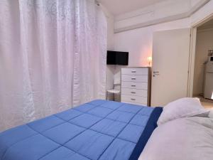 a bedroom with a large blue bed and a dresser at La Casa Di Giorgio in Sanremo