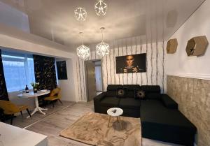 a living room with a black couch and a table at GOLD Apartment - Tomis Nord in Constanţa