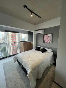 a bedroom with a bed and a large window at Metrô Santa Cruz Studio Novo in Sao Paulo