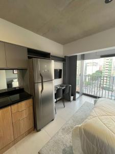 a kitchen with a refrigerator and a bed in a room at Metrô Santa Cruz Studio Novo in Sao Paulo