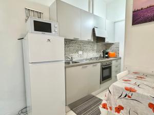 a white kitchen with a refrigerator and a sink at La Casa Di Giorgio in Sanremo