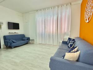 a living room with a blue couch and a tv at La Casa Di Giorgio in Sanremo