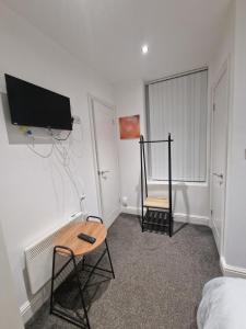 a bedroom with a tv on the wall and a chair at Lovely Double Bedroom in Liverpool