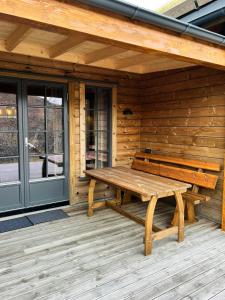 a wooden bench on the porch of a cabin at Modern Family Cabin At Vegglifjell in Veggli