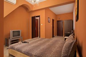 1 dormitorio con 1 cama y TV en Family Hotel Marsina en Sofía