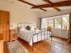 a bedroom with a bed and a large window at 1 Swollowholm Cottage in Richmond