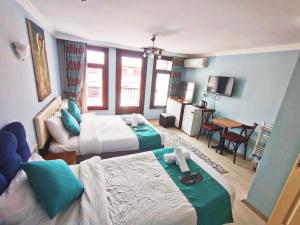 una habitación de hotel con dos camas y una mesa en Taksim Rose Residence Hotel, en Estambul