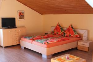 a bedroom with a bed and a flat screen tv at Ferienwohnungen Kasparbauer in Regen