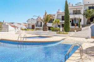 a swimming pool in front of a house at WELCS CASA ADOSADA 215 EMP con piscina comunitaria in Roses