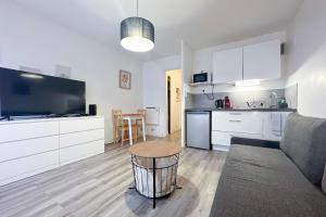 a kitchen and a living room with a couch and a table at #AR Le Saint François Hypercentre in Grenoble