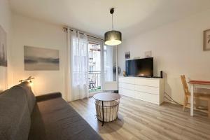 a living room with a couch and a tv and a table at #AR Le Saint François Hypercentre in Grenoble