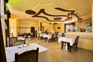 a dining room with white tables and chairs at Family Hotel Marsina in Sofia