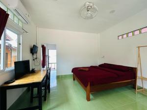 a bedroom with a bed and a desk with a computer at Lamsai AC Sea House Green in Ko Yao Noi