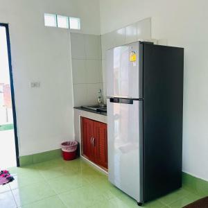 a kitchen with a black and white refrigerator at Lamsai AC Sea House Green in Ko Yao Noi