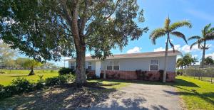 a house with a palm tree in front of it at Green Keys Ranch in Homestead