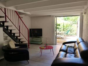 a living room with a couch and a television at HOSSEGOR Entre lac et océan Résidence LES DUNES, villa patio pour 4 à 5 personnes in Hossegor