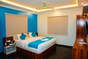 MuthugadahalliHotel Skylights Bangalore Airport的卧室里有一张大床，墙壁是蓝色的