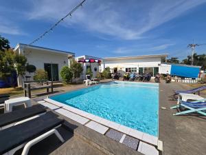 a swimming pool with chairs and a building at Aona Resort Kohlarn in Ko Larn