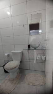 a white bathroom with a toilet and a sink at KITNET DU VÔ - Cantinho Du Vô in Santa Teresa