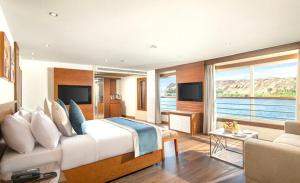 a bedroom with a large bed and a living room at Luxor Or Aswan Nile Cruise, Ultra Deluxe sailing 3, 4, Or 7 Nights in Luxor