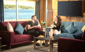 a man and a woman sitting in a living room at Luxor Or Aswan Nile Cruise, Ultra Deluxe sailing 3, 4, Or 7 Nights in Luxor