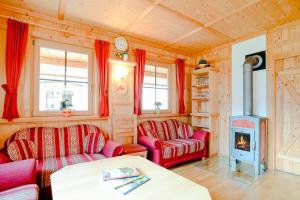 a living room with two red couches and a fireplace at Ferienhaus Eberharter in Schwendau