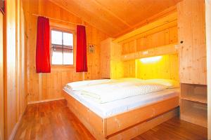 a bedroom with a bed in a wooden cabin at Ferienhaus Eberharter in Schwendau +9 photos
